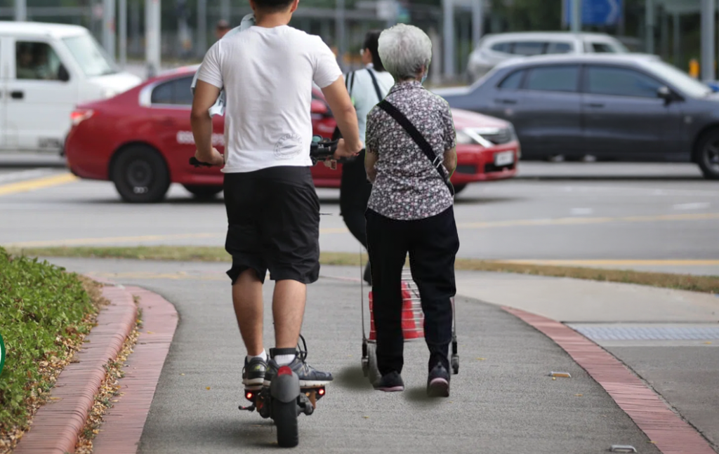 PMD rider behind elderly walking